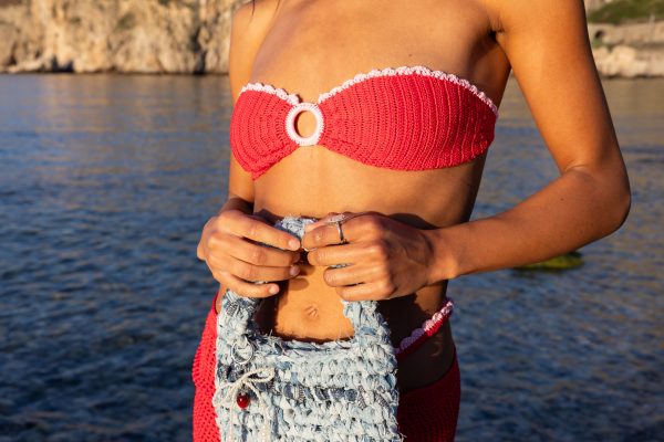 Borsa artigianale in jeans intrecciato, modello Etnea by Elisabeth Fashion, in primo piano su sfondo marino.