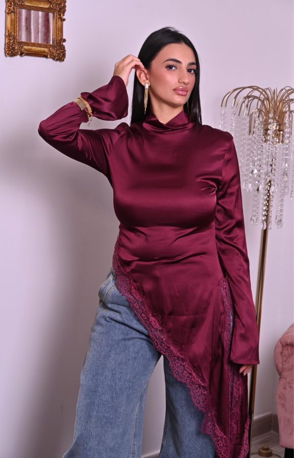 Blusa in satin borgogna con pizzo e taglio asimmetrico, elegante e raffinata.