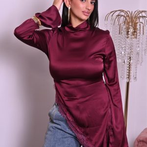 Blusa in satin borgogna con pizzo e taglio asimmetrico, elegante e raffinata.