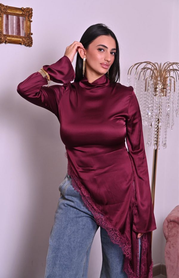 Blusa in satin borgogna con pizzo e taglio asimmetrico, elegante e raffinata.