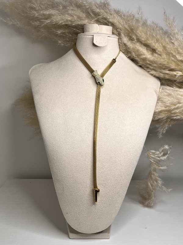 Un serpente dorato che avvolge il décolleté con eleganza ipnotica. Brilla di cristalli e scivola lungo il corpo con fascino irresistibile.