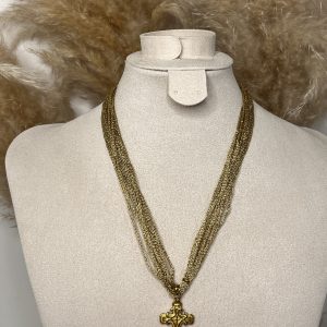 Collana a più fili dorati con ciondolo a croce decorata, elegante e dal carattere deciso.