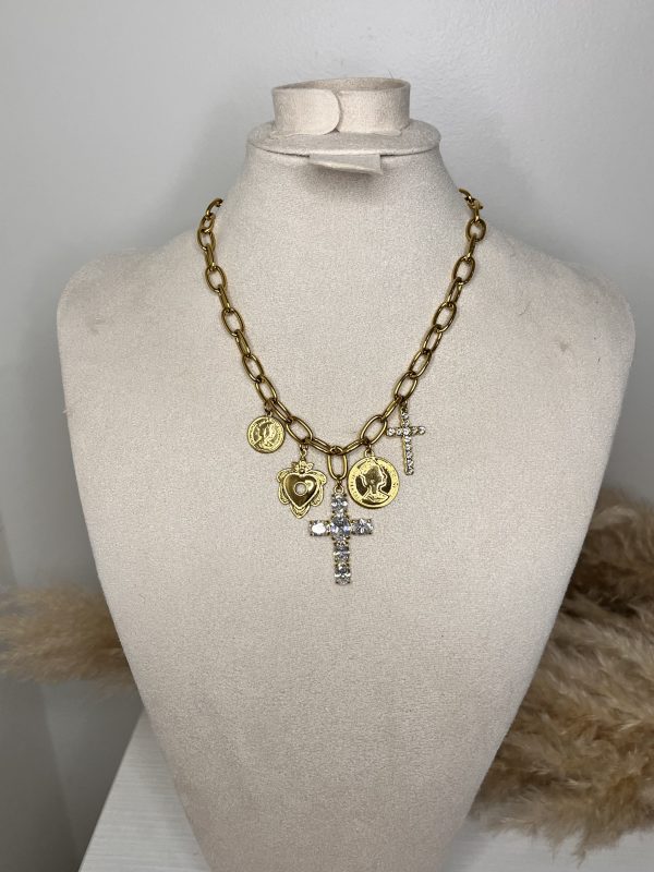 Collana dorata a catena con ciondoli simbolici e croce tempestata di cristalli. Un accessorio luminoso e dal carattere deciso, perfetto per valorizzare ogni look.