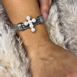 Bracciale argentato elegante con croce centrale impreziosita da perle. Un dettaglio raffinato che unisce simbolismo e stile senza tempo.