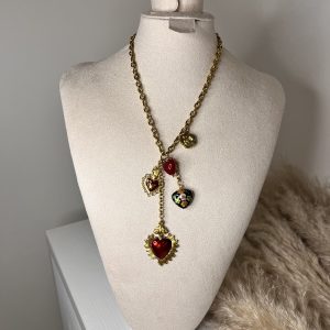 Collana dorata con pendenti a cuore smaltati e dettagli floreali, disposti a cascata per un effetto elegante e romantico.