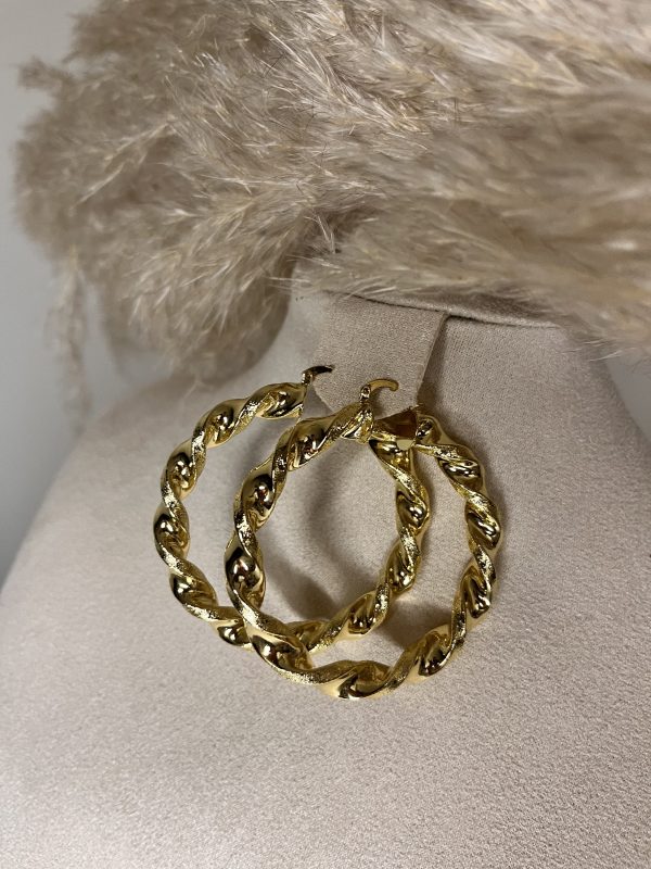 Cerchi dorati intrecciati dal design elegante e deciso. Perfetti per aggiungere luce e personalità a ogni look.