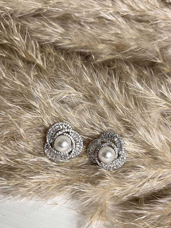 Orecchini a fiore con perla centrale e dettagli argentati luminosi. Un gioiello raffinato e senza tempo, simbolo di pura eleganza.