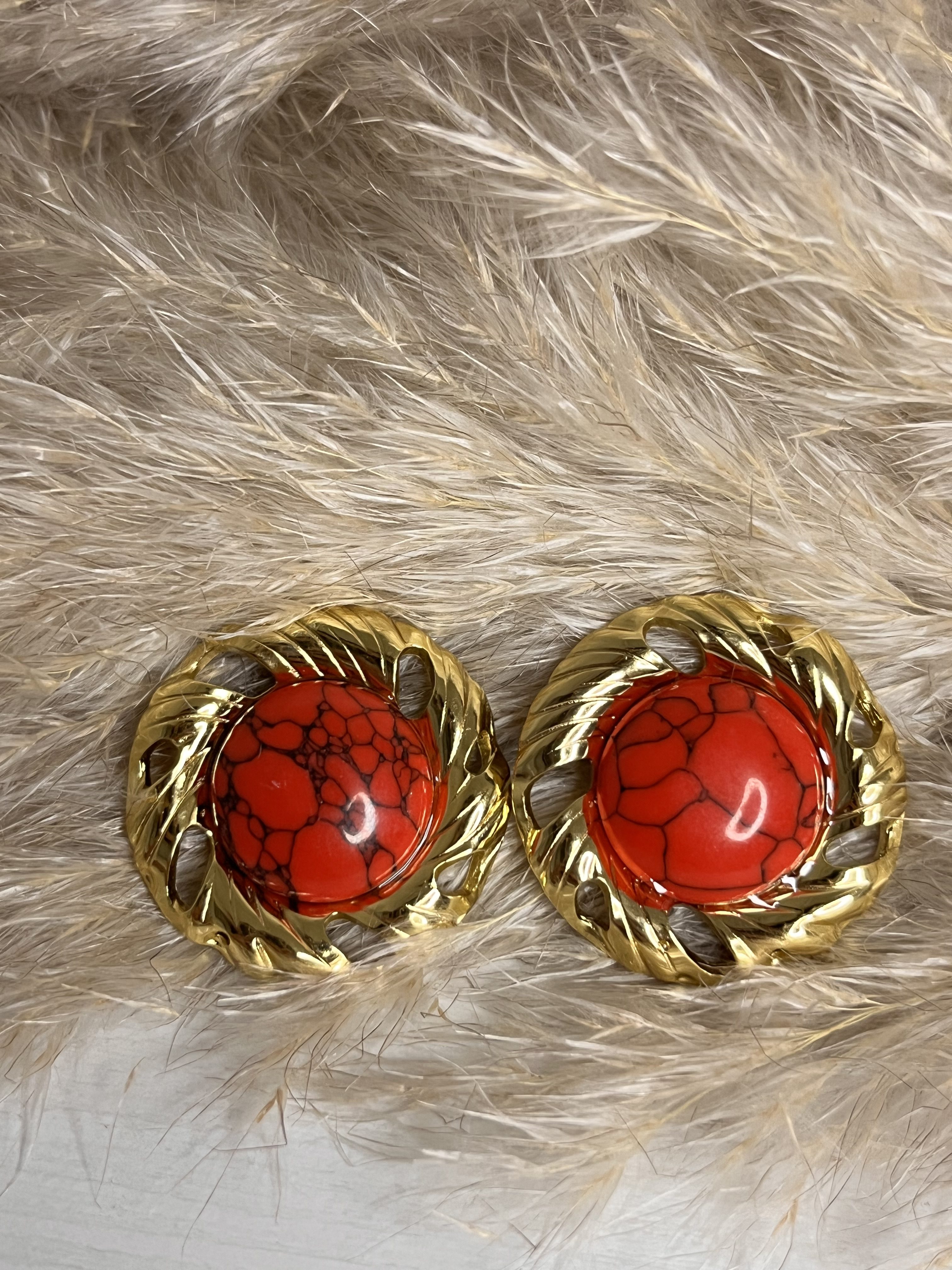 Vuoi un accessorio che parli di te? Questi orecchini Elisabeth Fashion sono la scelta giusta! Con la loro montatura bold dorata e la gemma rosso ciliegia con effetto "cracklé", sono perfetti per dare un twist glamour-retrò a ogni outfit. Il dettaglio che fa la differenza!