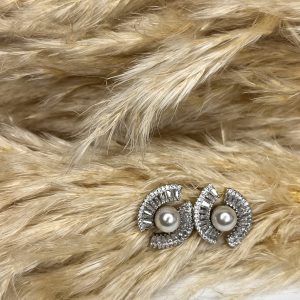 Un must-have di classe! Questi orecchini Elisabeth Fashion combinano la morbidezza della perla centrale con l'incredibile luminosità degli strass a raggiera. Il design semi-cerchio è moderno e raffinato, perfetto per dare un tocco elegante e chic al tuo look.