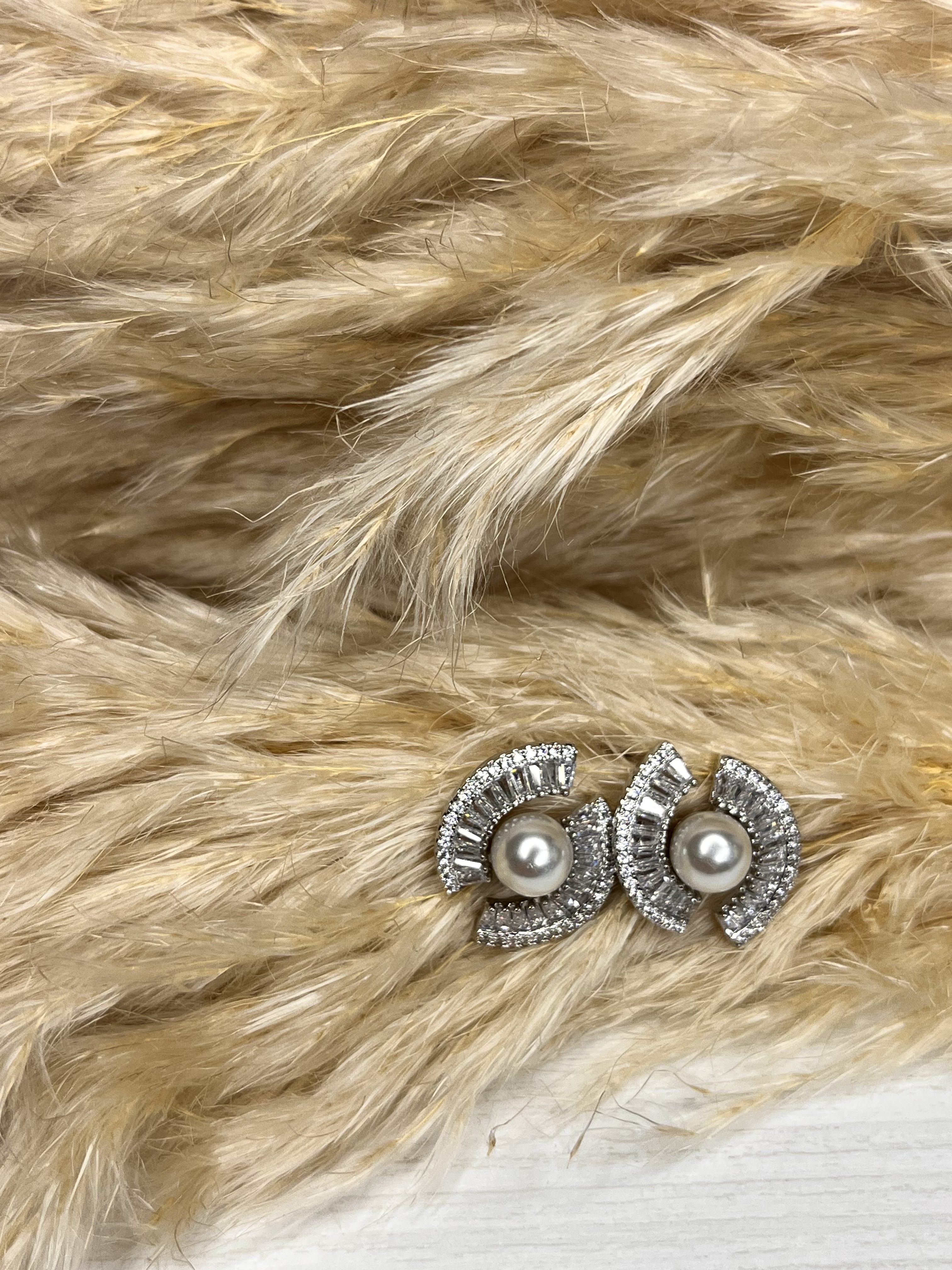 Un must-have di classe! Questi orecchini Elisabeth Fashion combinano la morbidezza della perla centrale con l'incredibile luminosità degli strass a raggiera. Il design semi-cerchio è moderno e raffinato, perfetto per dare un tocco elegante e chic al tuo look.