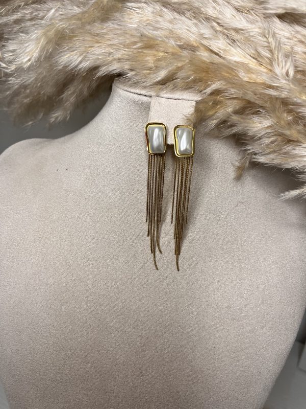Massimo glamour con gli Orecchini Luxe Frange Elisabeth Fashion! Design pendente con una gemma rettangolare effetto madreperla e una cascata di catenine color oro. Un accessorio elegante e audace che dona movimento e un tocco super chic ad ogni look.