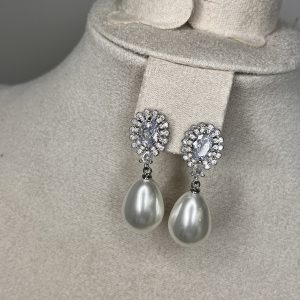 Eleganza senza tempo! Questi orecchini pendenti Elisabeth Fashion uniscono la brillantezza degli strass scintillanti (a forma di fiore) al fascino raffinato della grande perla a goccia lucida. L'accessorio perfetto per un look da vera Diva elegante e chic.