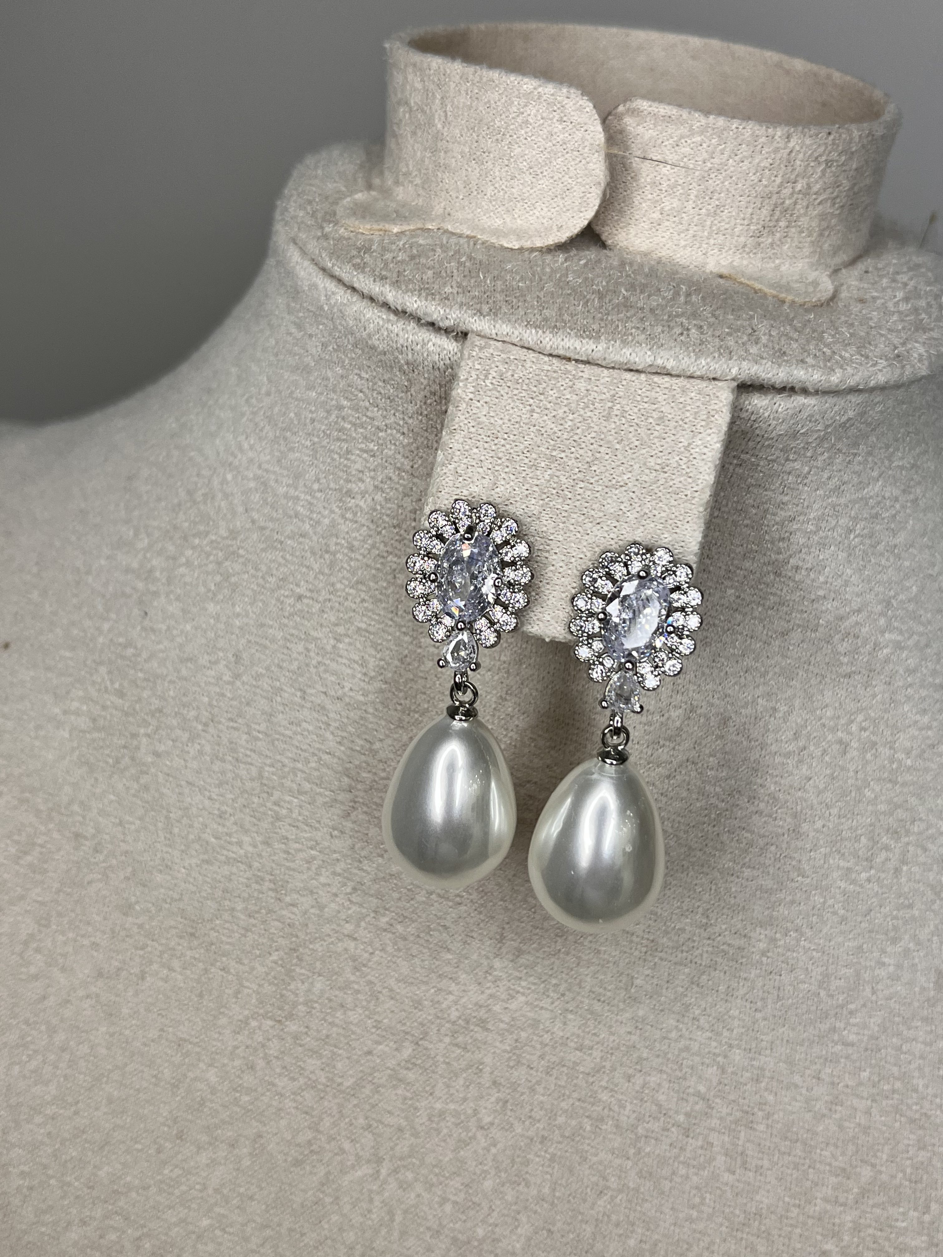 Eleganza senza tempo! Questi orecchini pendenti Elisabeth Fashion uniscono la brillantezza degli strass scintillanti (a forma di fiore) al fascino raffinato della grande perla a goccia lucida. L'accessorio perfetto per un look da vera Diva elegante e chic.