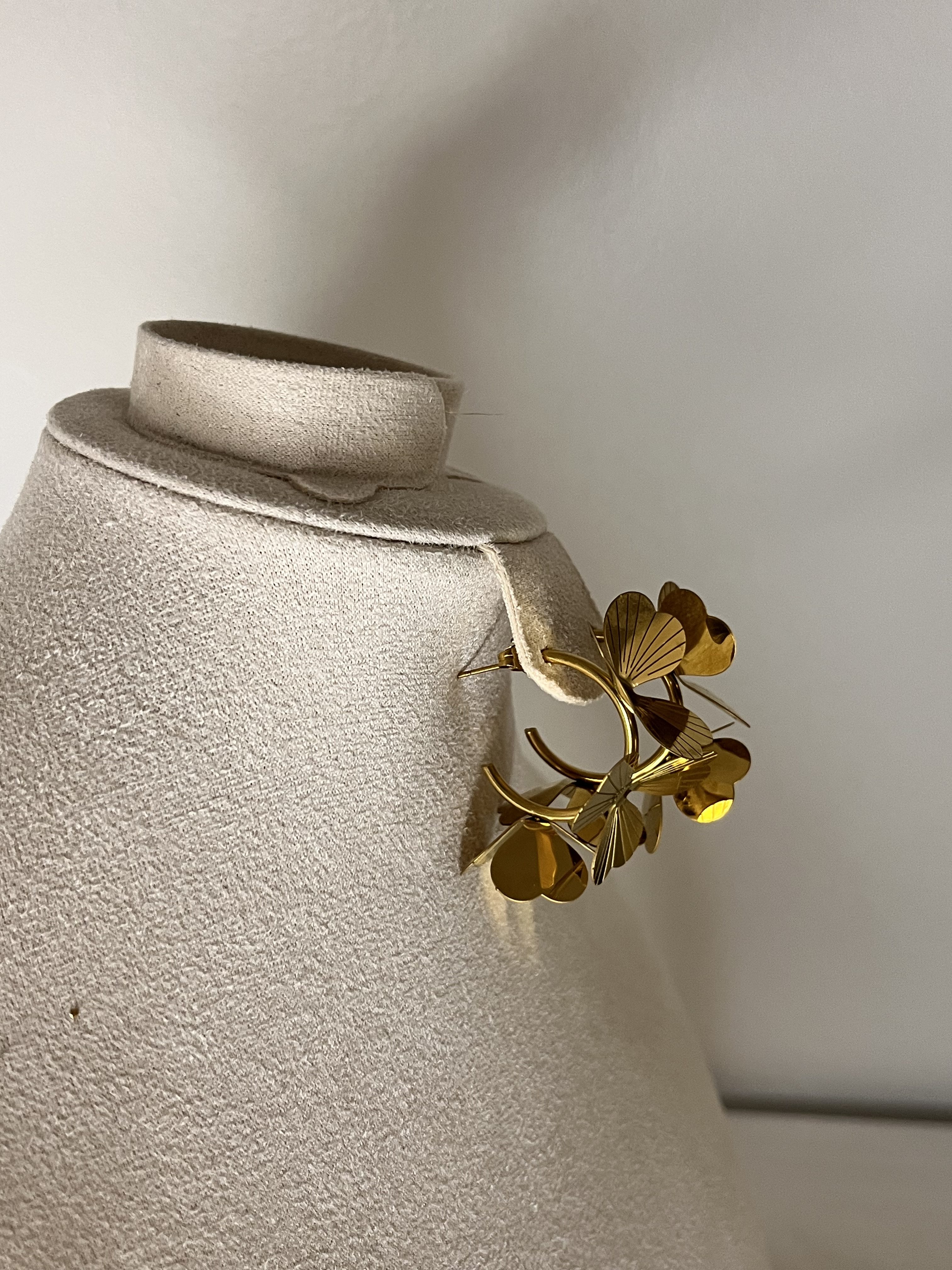 Un bouquet di stile! Questi orecchini Elisabeth Fashion sono a cerchio, impreziositi da fiori in metallo dorato lucido con una texture elegante. Un accessorio artistico e glamour, perfetto per un look Diva che ama osare con un tocco cool e originale.