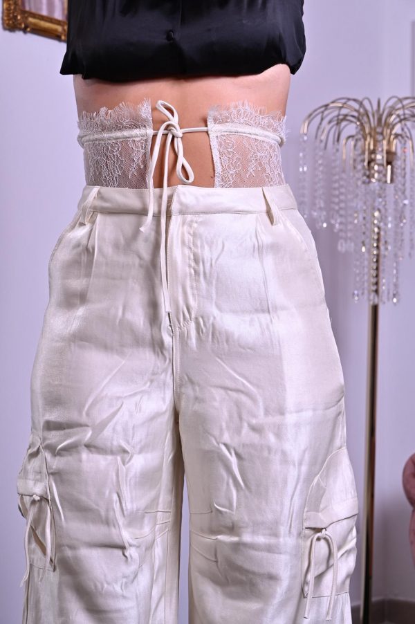 Pantalone cargo satinato vita alta con fascia in pizzo e tasche laterali. Elegante e moderno.