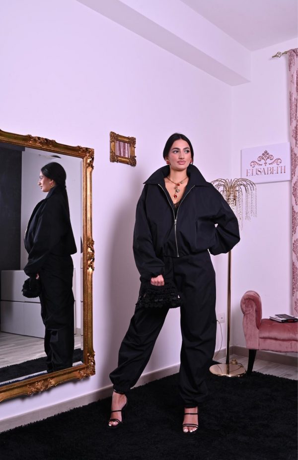 Tuta nera con zip, colletto maxi e fondo jogger a caviglia, dallo stile moderno e chic.