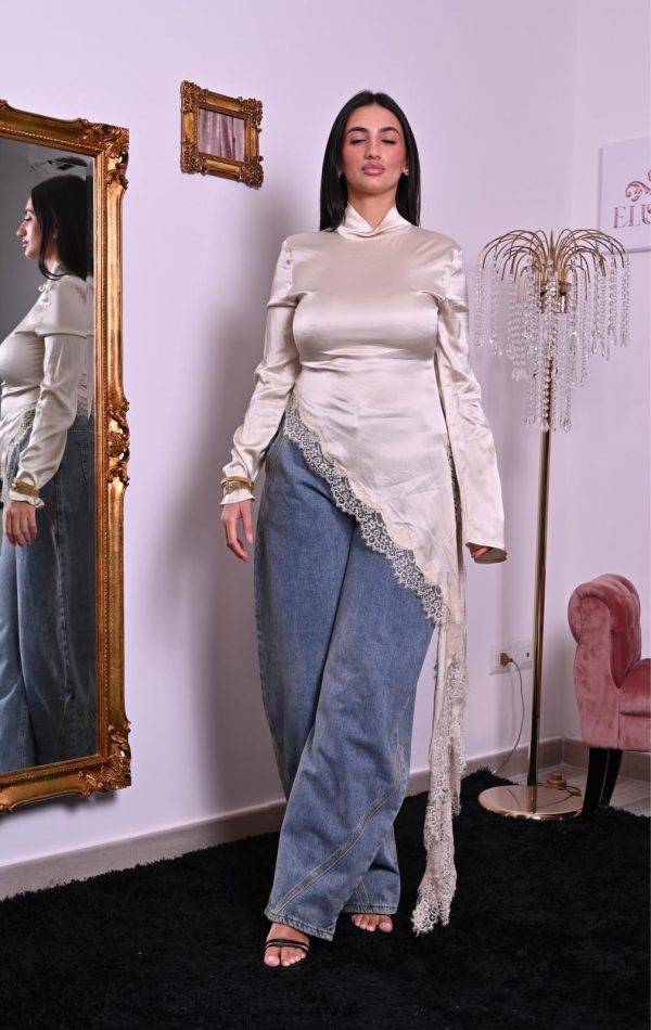 Blusa in satin color avorio con inserti in pizzo e taglio asimmetrico, elegante e raffinata.