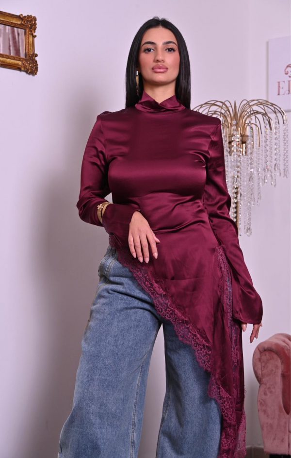 Blusa in satin borgogna con pizzo e taglio asimmetrico, elegante e raffinata.