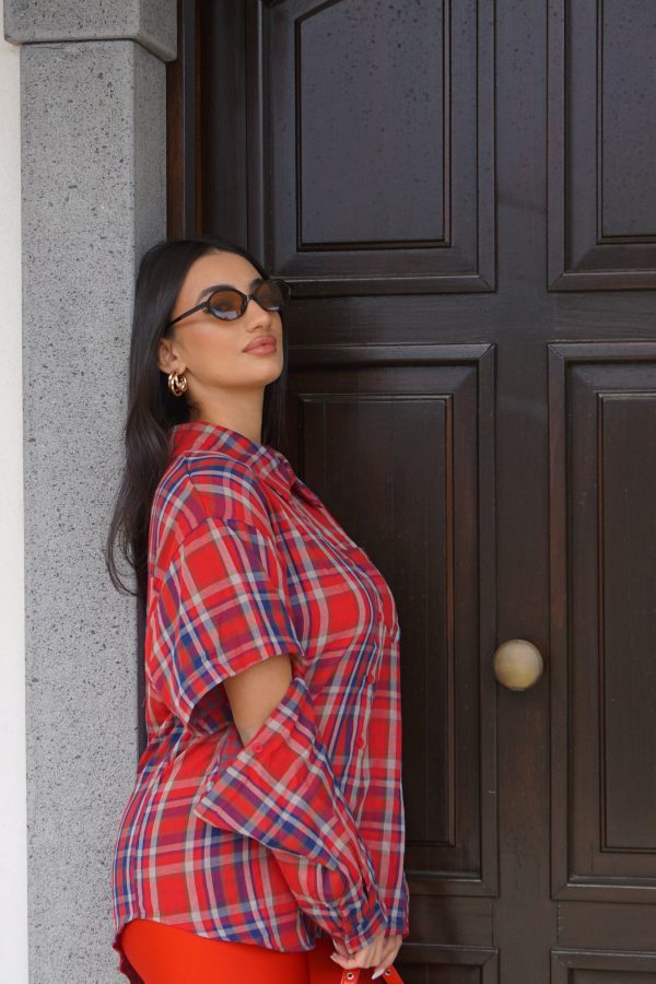 Camicia a quadri rossi con maniche staccabili tramite bottoni: un capo 2-in-1 versatile e originale, perfetto per look dinamici e contemporanei.