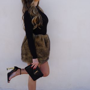 Un vestito unico che combina un top in lycra nera dal fit avvolgente con una gonna in morbida pelliccia sintetica, per un look sofisticato e irresistibile.