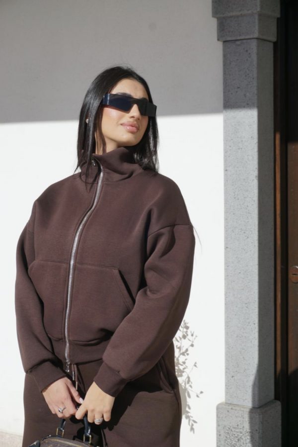 Tuta marrone in stile casual, con felpa oversize full zip e pantaloni larghi coordinati, dal look moderno e minimal.