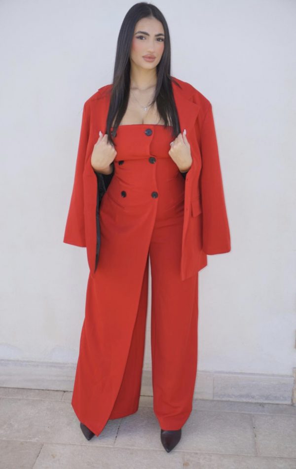 Tuta elegante rossa con bottoni frontali, abbinata a giacca oversize coordinata: un completo sofisticato e di carattere, perfetto per occasioni speciali.