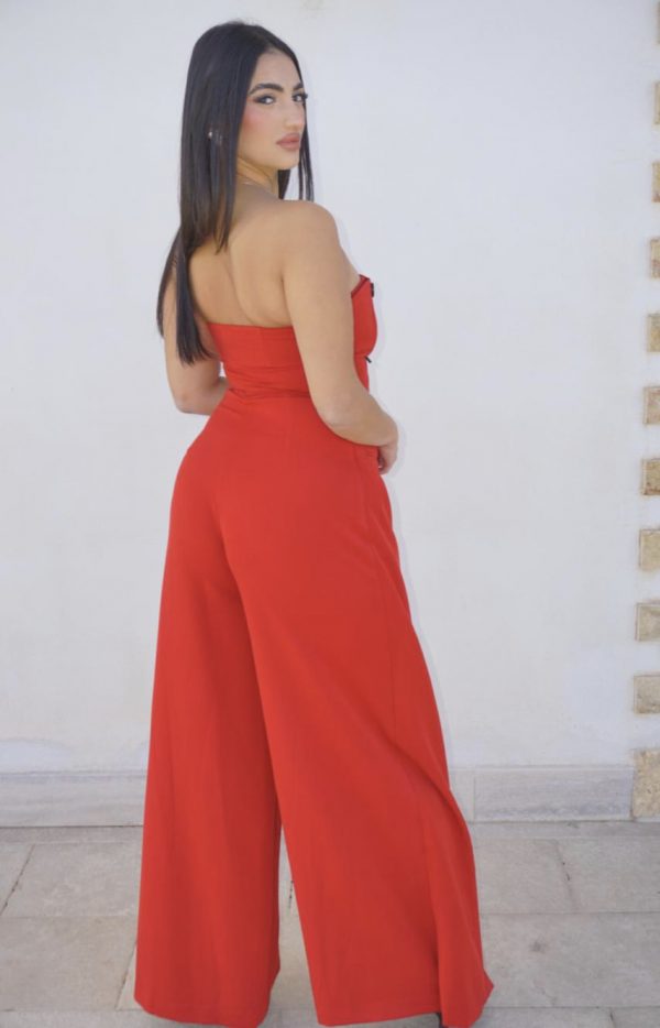 Tuta elegante rossa con bottoni frontali, abbinata a giacca oversize coordinata: un completo sofisticato e di carattere, perfetto per occasioni speciali.